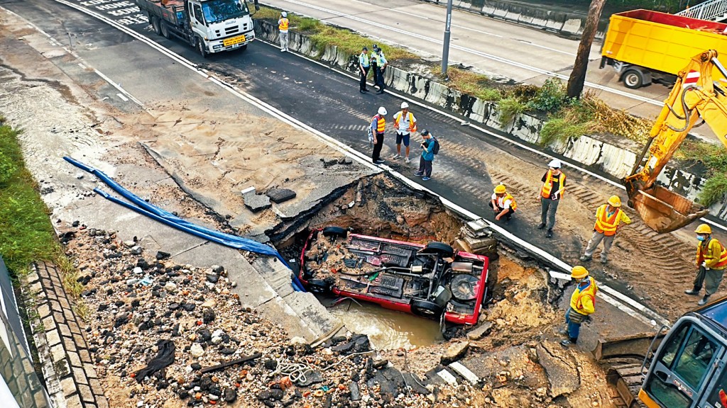 荔枝角道馬路疑因地下水管爆裂路陷，一輛的士駛經墮入深坑被淹沒。