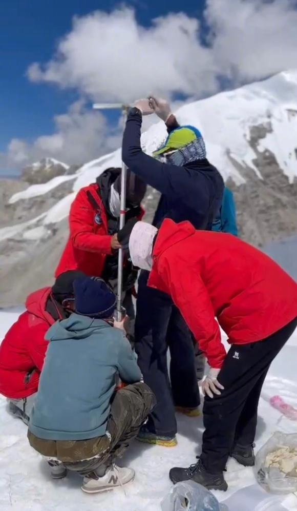 科考队员在山顶探集冰芯数据。新华社