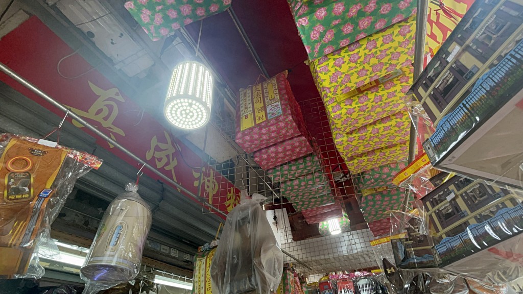 紙紮舖門口掛了不少衣包。楊偉亨攝 紙紮舖門口掛了不少衣包。楊偉亨攝