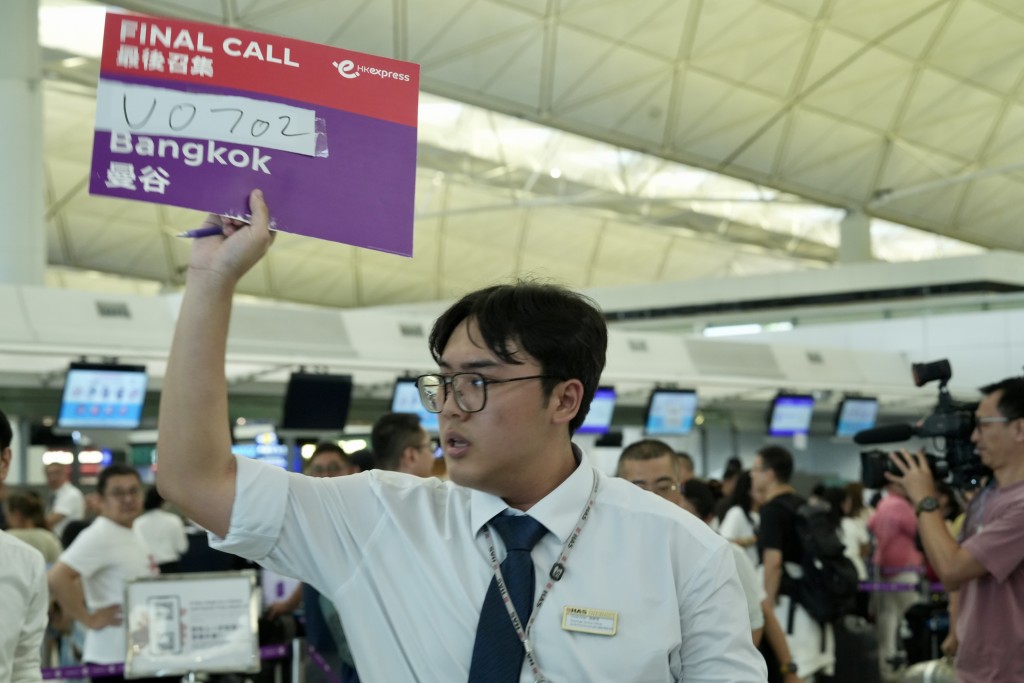 昨日有航空公司職員用手寫牌安排乘客登機。劉駿軒攝