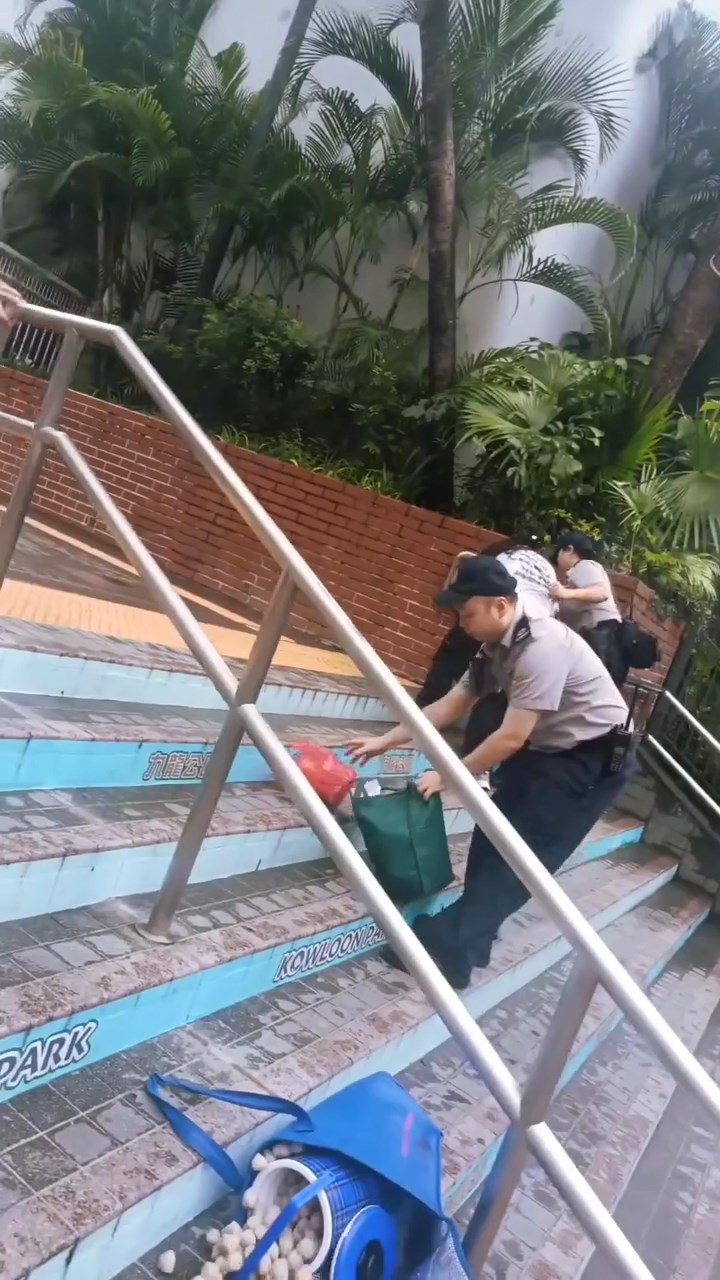 女子的物品散落一地,需要食環署人員執拾。網上片段截圖 女子的物品散落一地,需要食環署人員執拾。網上片段截圖