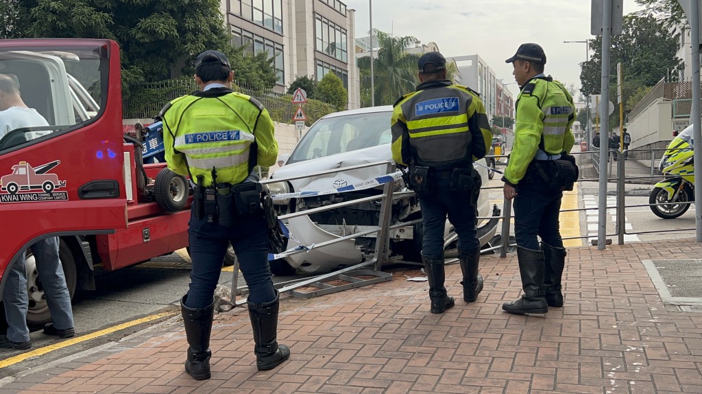 白色私家車撞向鐵欄。林思明攝