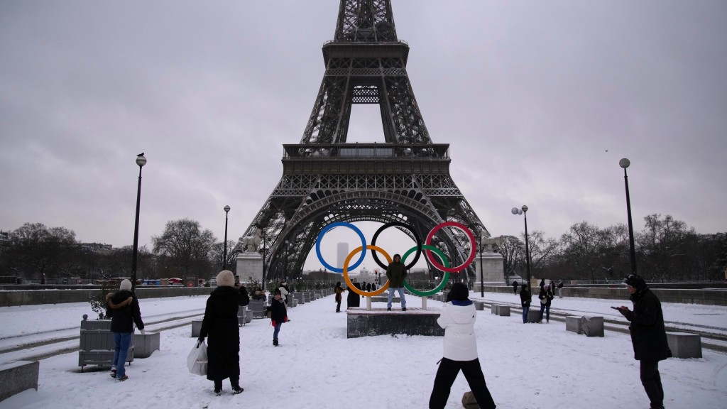 歐洲暴雪｜人們在雪中與艾菲爾鐵塔拍照。 美聯社