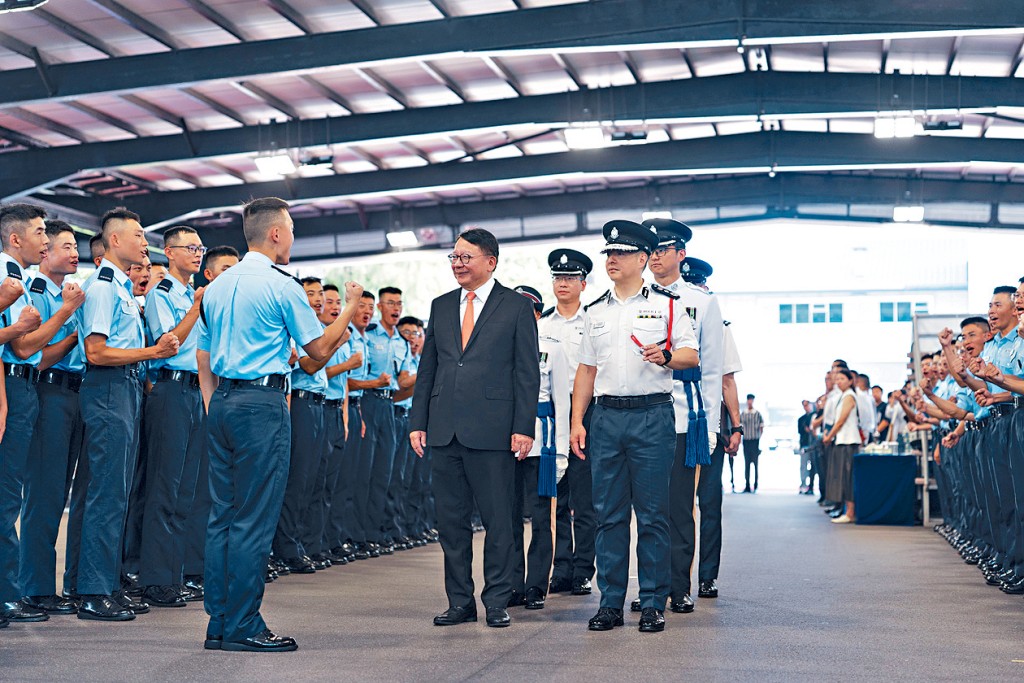 政務司司長陳國基昨出席警察學院結業會操後,在警務處處長周一鳴陪同下與結業學員交流。