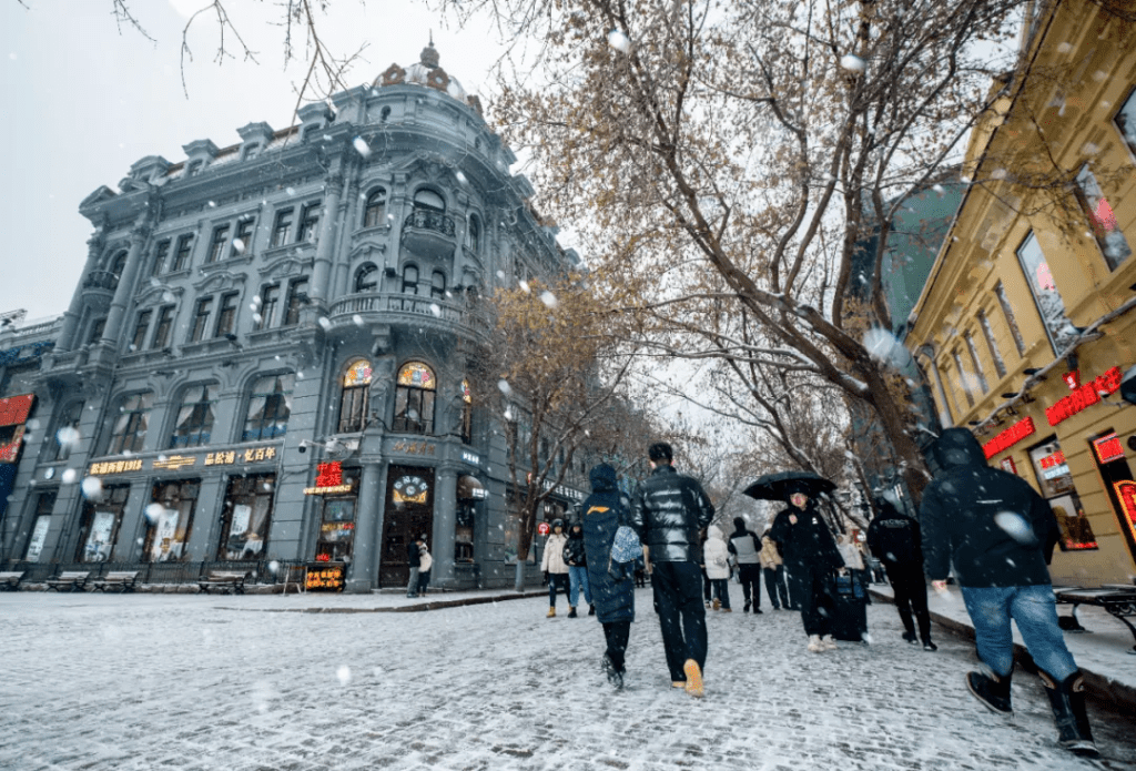 11月26日，市民遊客在雪中的哈爾濱中央大街步行街行走。新華社