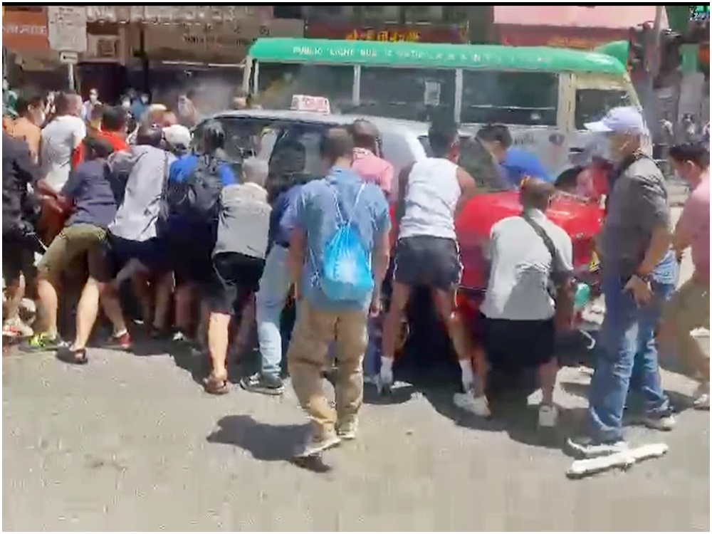 孕婦遭捲入車底,獲途人合力抬車救出。網圖