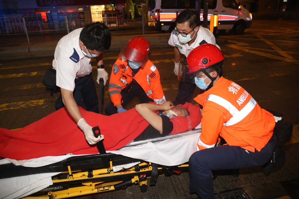 女途人被撞向拦杆后倒地重伤，由救护员送伊利沙伯医院救治。李家杰摄