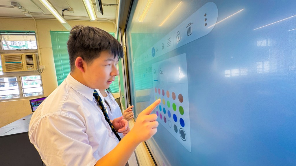 轻触崭新教学设备，郑资重温当年在母校的学习乐趣。（图片来源：台山商会学校）