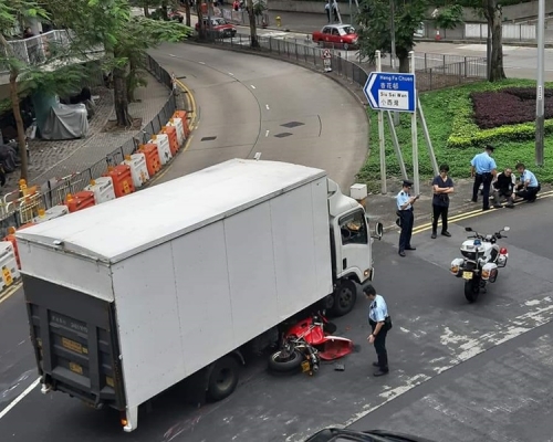 電單車翻側倒地,幾乎捲入貨車車底。