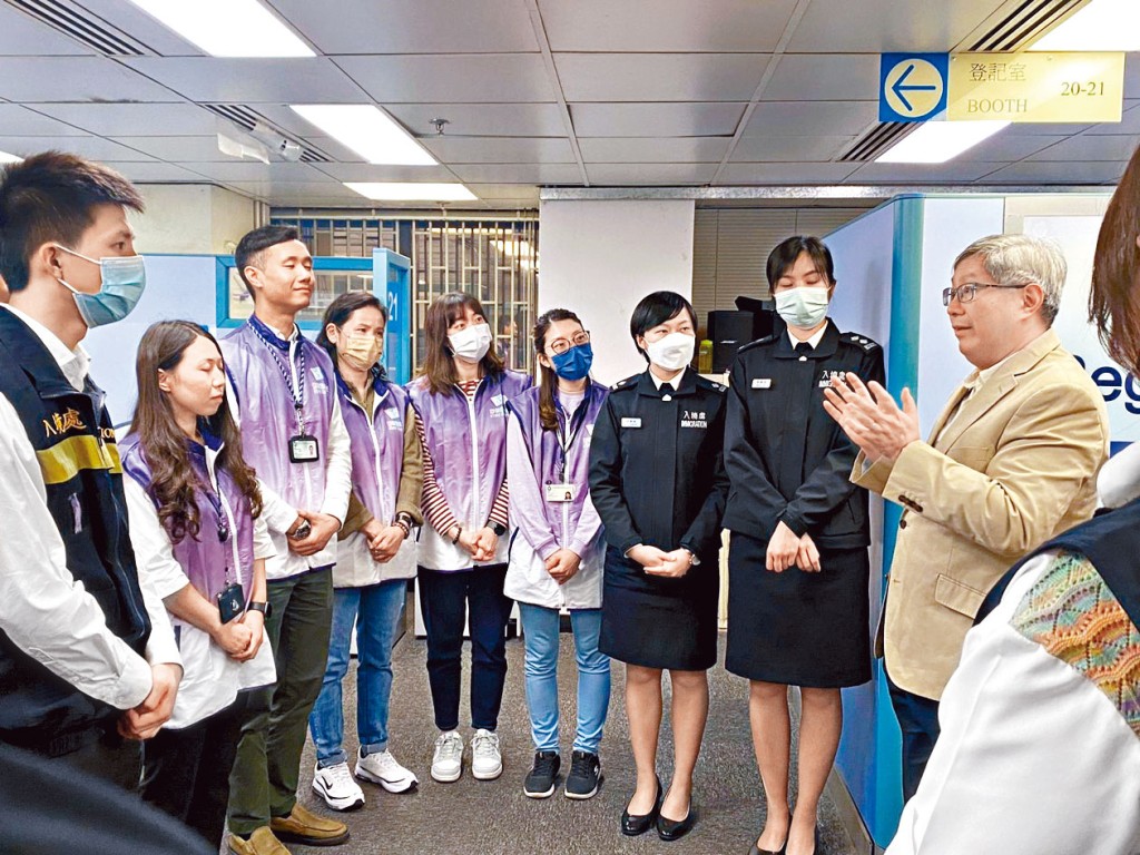入境處處長區嘉宏（右）到港島人事登記辦事處，了解特別服務日運作情況。
