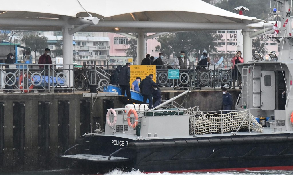 食环署职员将两名男死者遗体，抬往长洲码头。