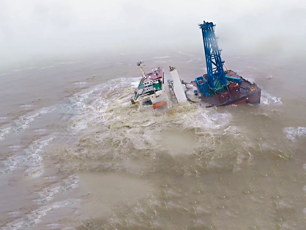 工程船半截船身在怒海中漂浮。