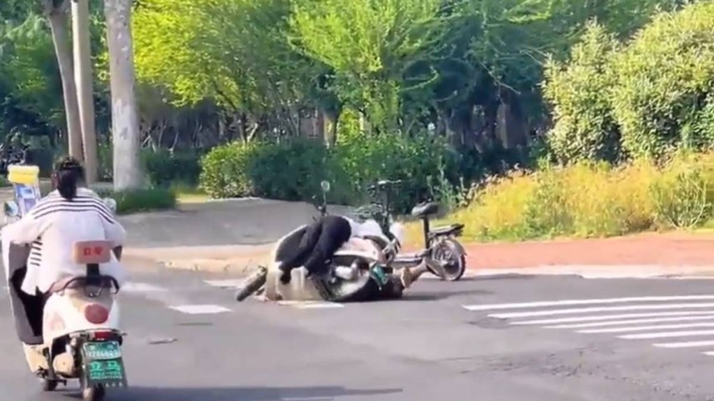 好心女途人抬車時失手，連人帶車重壓倒地男司機。微博