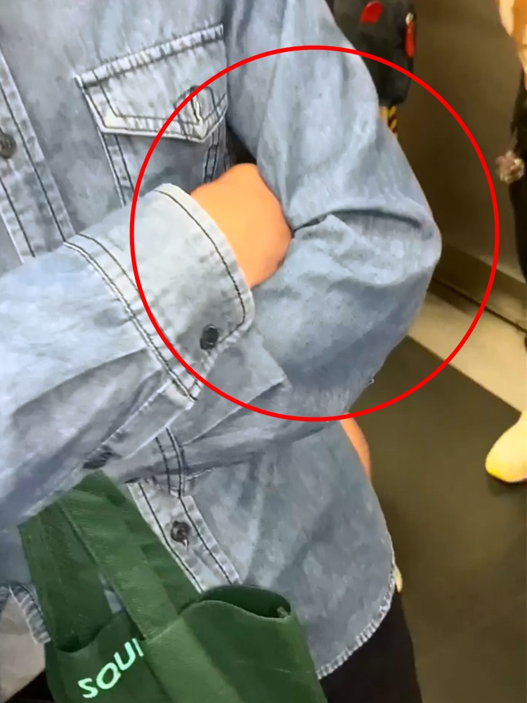 大叔手機握在胸前(紅圈),懷疑偷拍。香港突發事故報料區facebook群組影片截圖