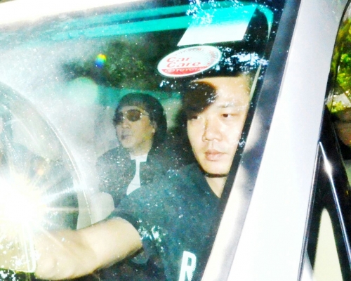 郭永鸿（左）由一辆七人车接载离开西区警署。