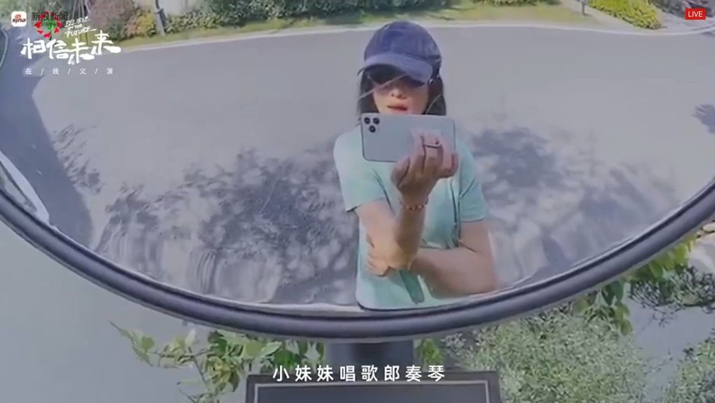 周迅攞住手機透過路邊鏡子反射自拍。