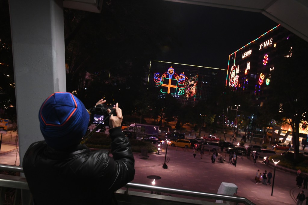 市民带着相机到尖东拍摄圣诞灯饰。何健勇摄