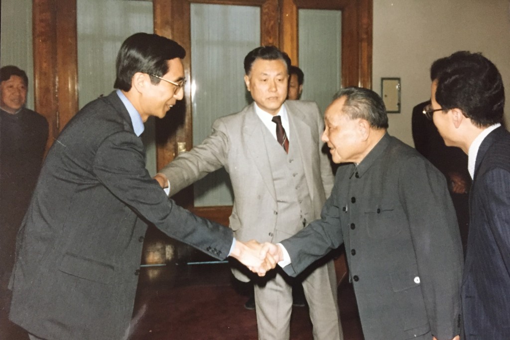 鄧小平（右）接見東日本國際大學客座教授西園寺一晃（左）。（中新社）