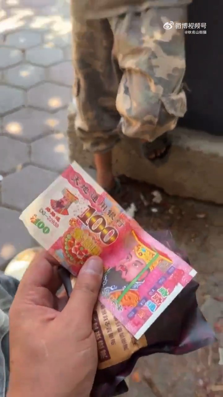 另一名網紅將一張陰司紙交予小孩。