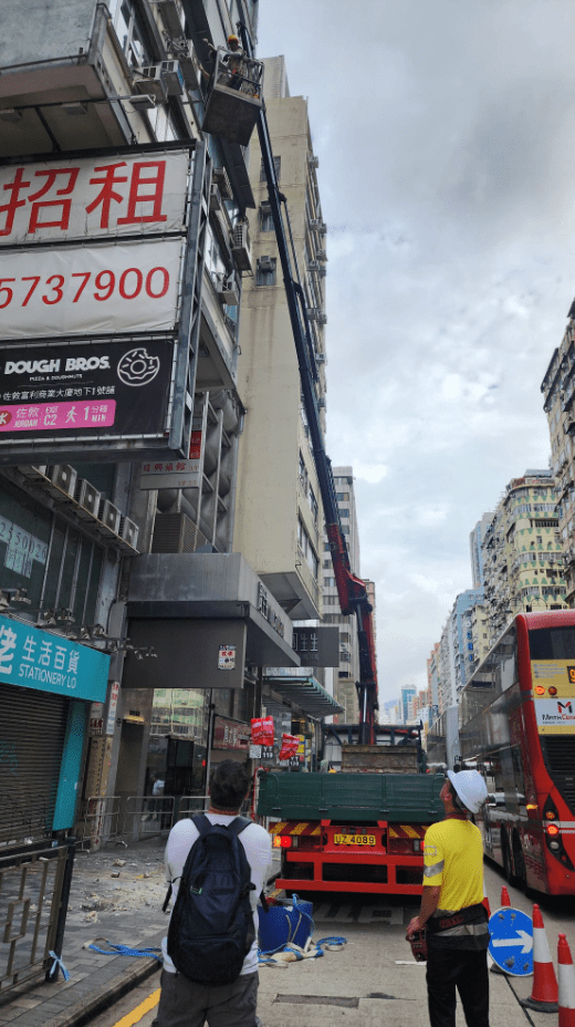路政署人員乘坐升降台，在三樓外牆視察及紀錄情況。黎志偉攝