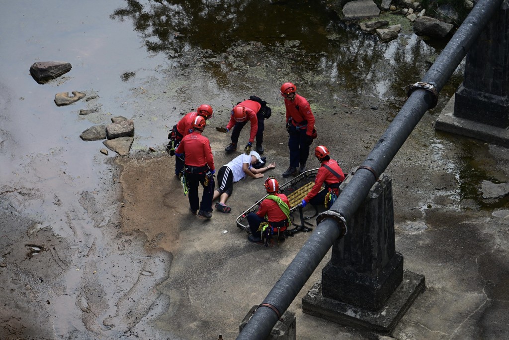 演习中，民安队在香港仔下水塘一带，游绳落水坝拯救一名昏迷女子。陈极彰摄