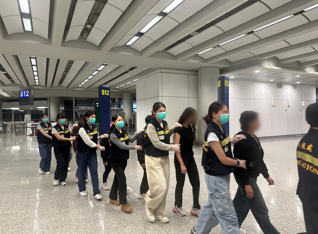被遣返人士在入境處人員押送下離港。 被遣返人士在入境處人員押送下離港。