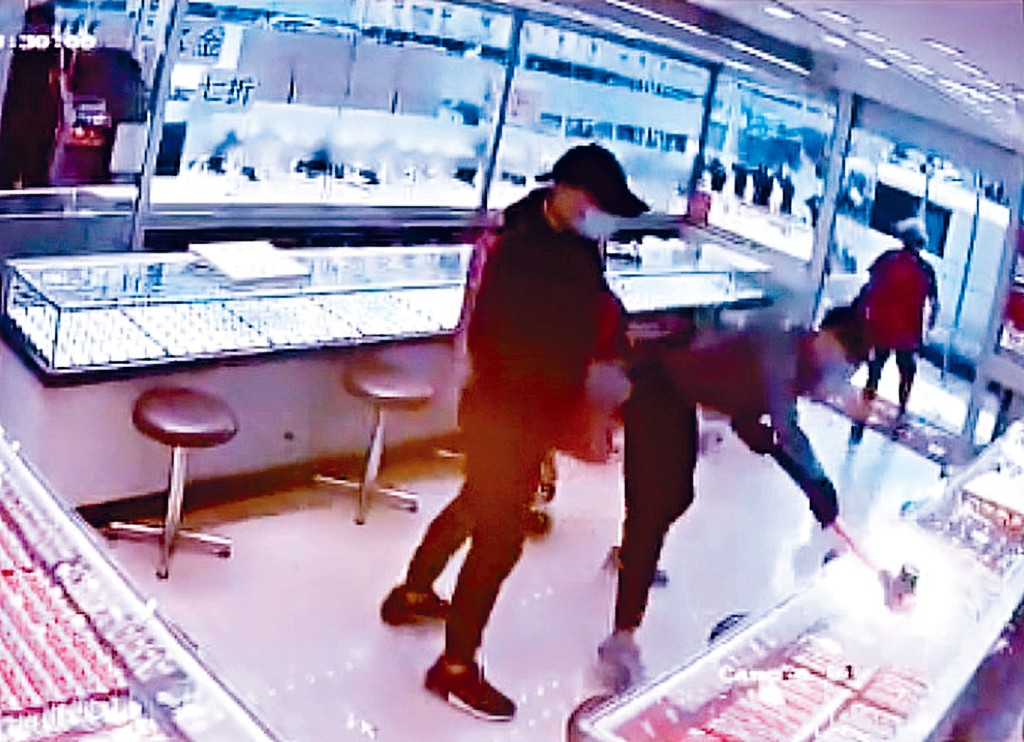 兩匪闖進金行揮鐵錘扑飾櫃打劫，女顧客驚惶離開。