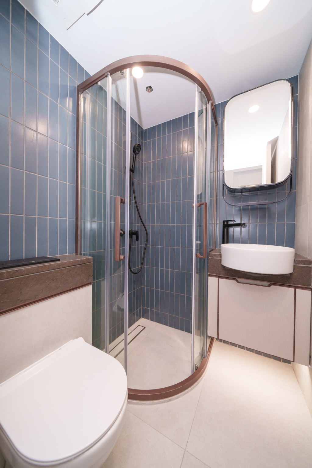 浴室牆身以米色配搭時尚藍色瓷磚打造
