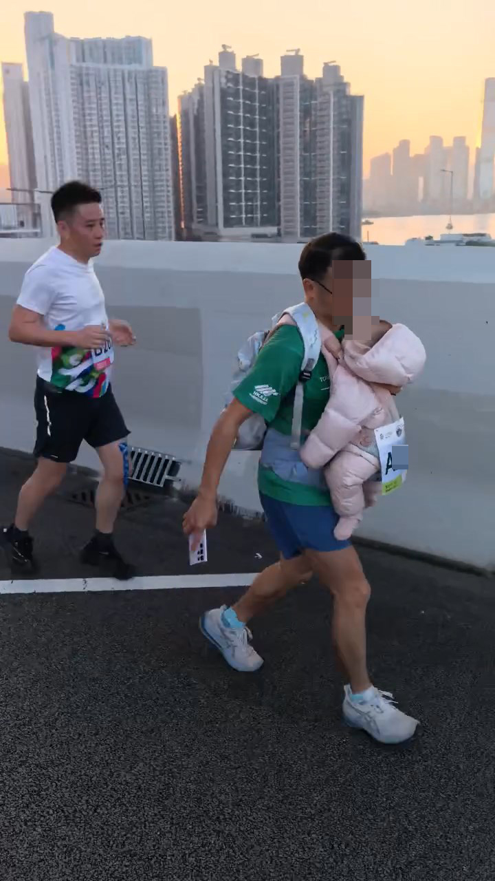 一名男跑手孭住一名嬰兒參加全馬比賽。threads@lamhontai_影片截圖