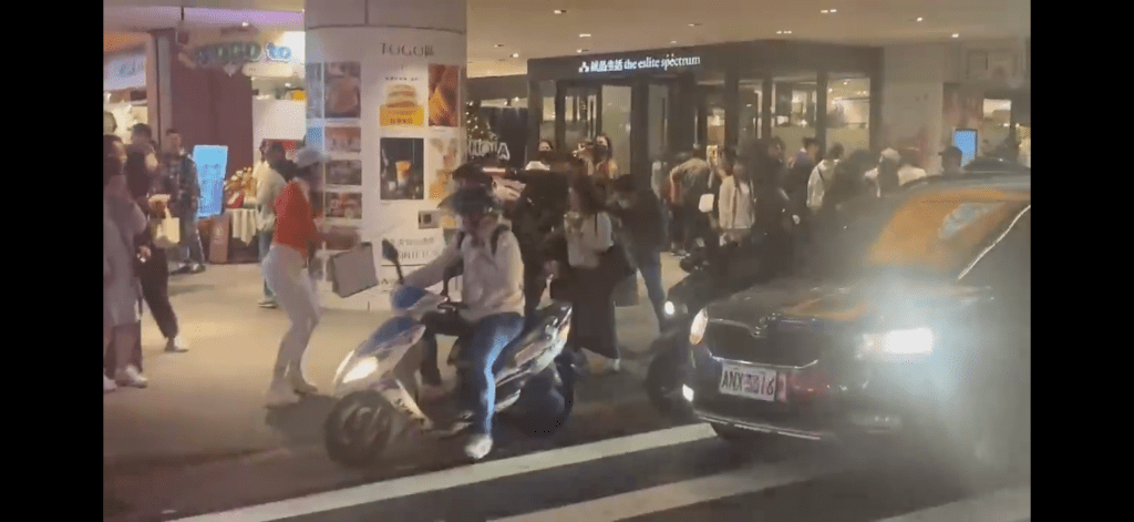 張文經過一群人時舉手揮刀。 張文經過一群人時舉手揮刀。