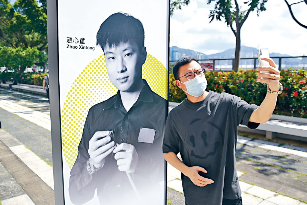 球迷張先生昨在趙心童的海報前留影。