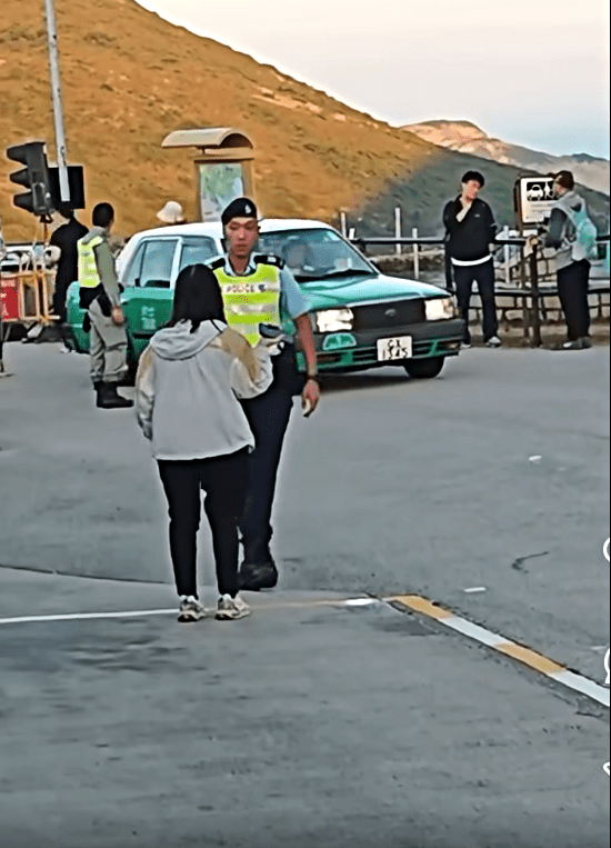 一名女子走向警員查詢為何有人可以不排隊登車。fb：車cam L（香港群組）