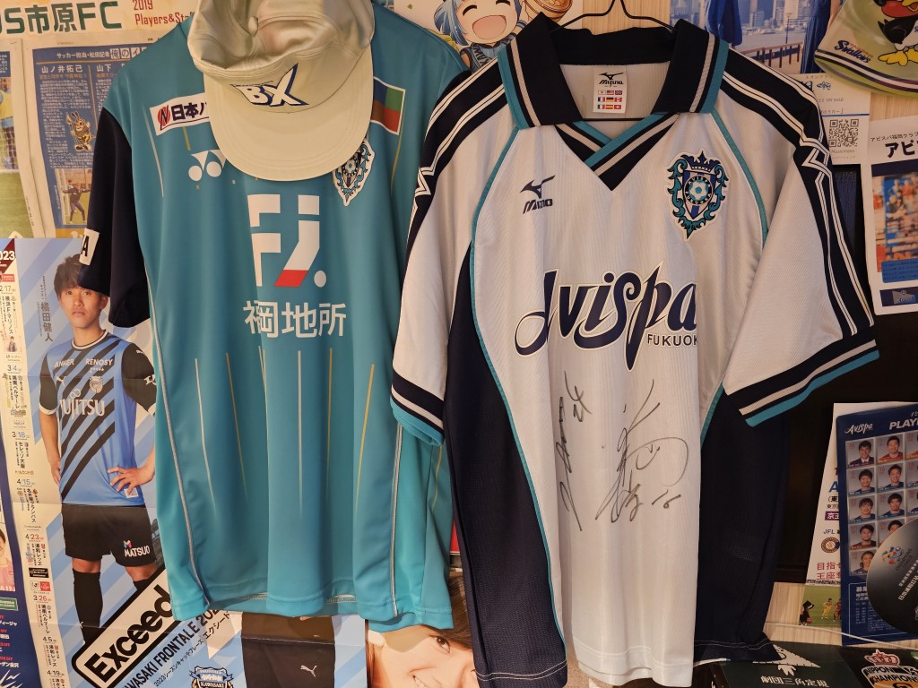 河野創向小記展示他家鄉球隊福岡黃蜂的兩件簽名球衣。
