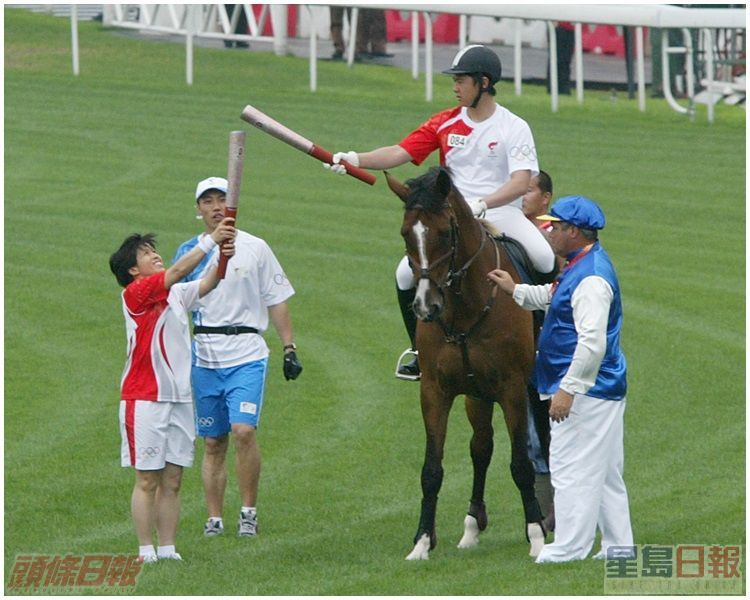 陈念慈(左)从马上的郑文杰手中接过圣火。资料图片