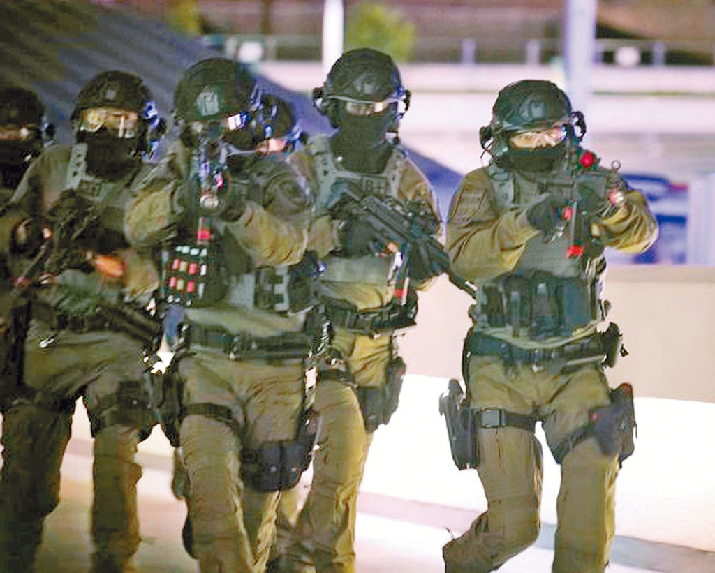 警方反恐特勤隊人員在演練中,擎槍狙擊恐怖分子。