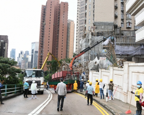 工人用吊臂車協助移走塌下的棚架。楊偉亨攝
