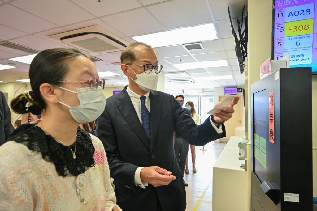 卢宠茂在柏立基普通科门诊诊所听取医护人员讲解诊所的运作流程。政府新闻处图片