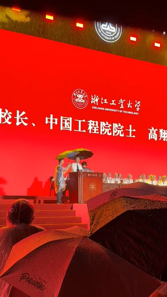 兩學生上台替校長舉傘。 兩學生上台替校長舉傘。