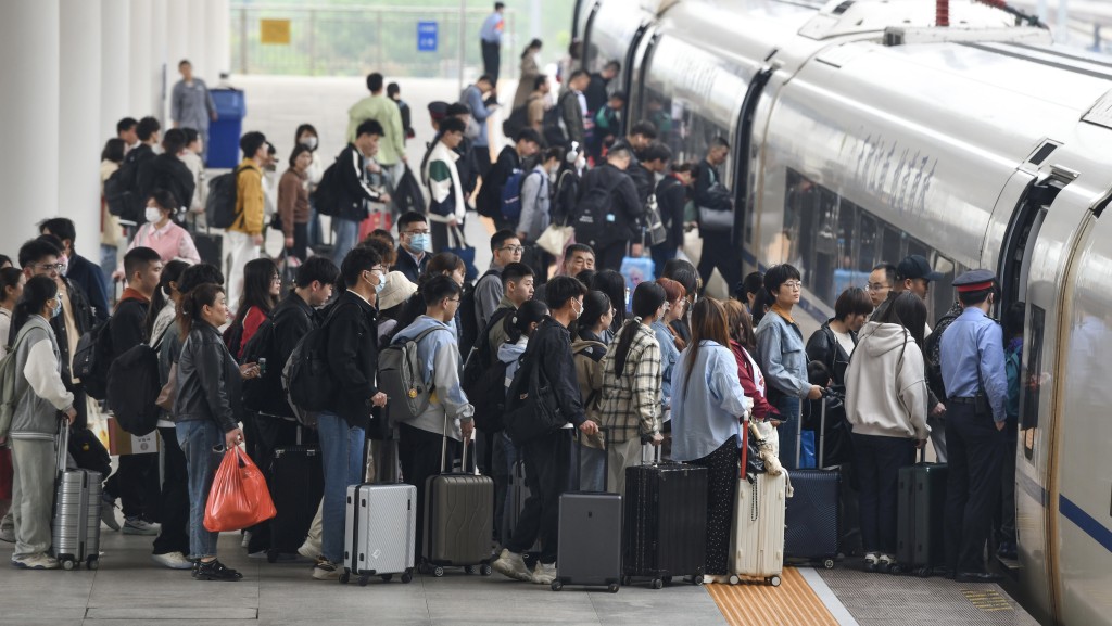 安徽阜陽西站旅客在五一假期最後一天排隊乘車。 新華社