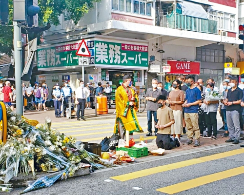 男死者儿子跪地致祭，亲友亦在场路祭，场面哀伤。