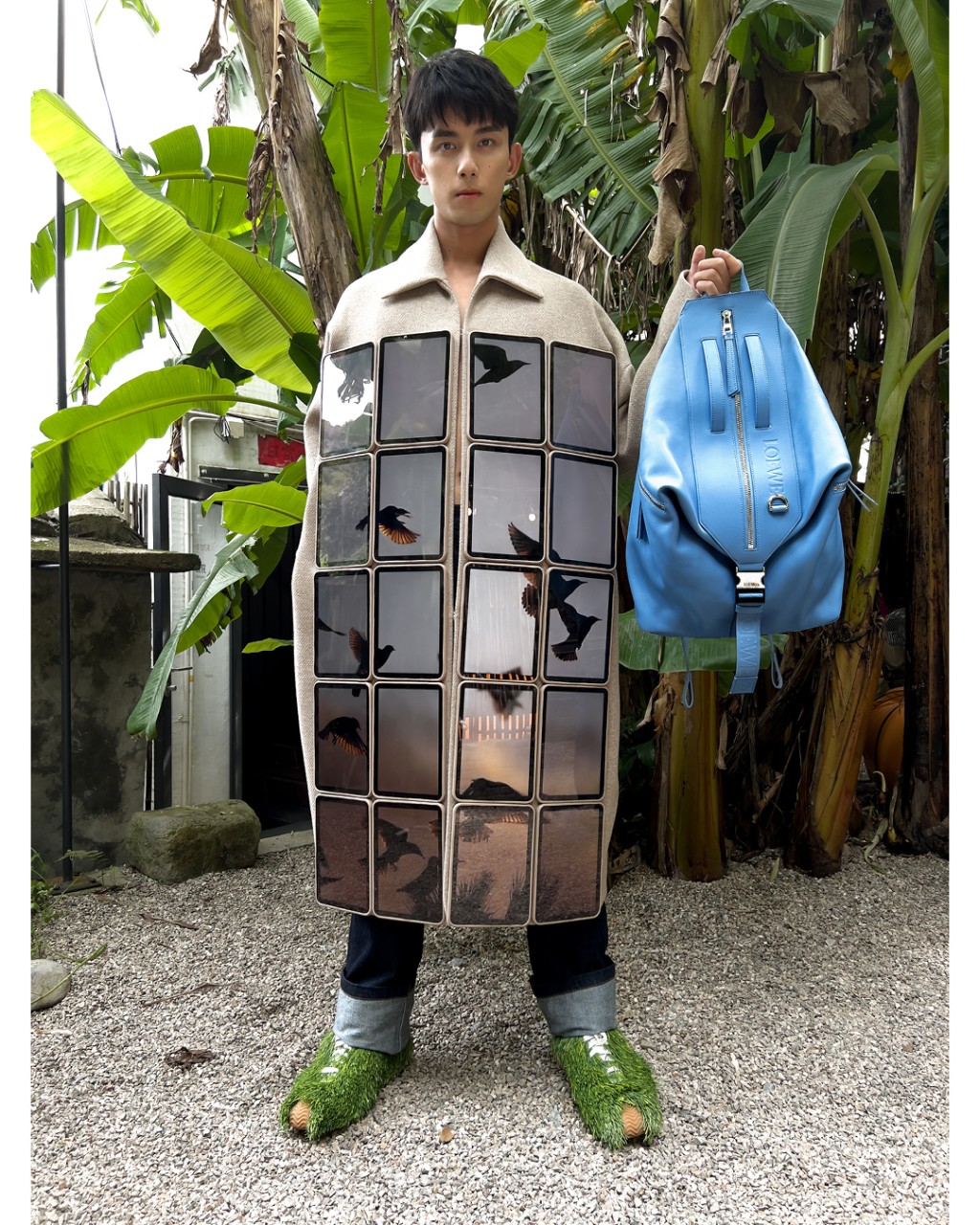 吳磊這襲大衣配襯牛仔褲、綠色毛毛鞋及藍色背囊，造型玩味，切合設計師的創作風格。