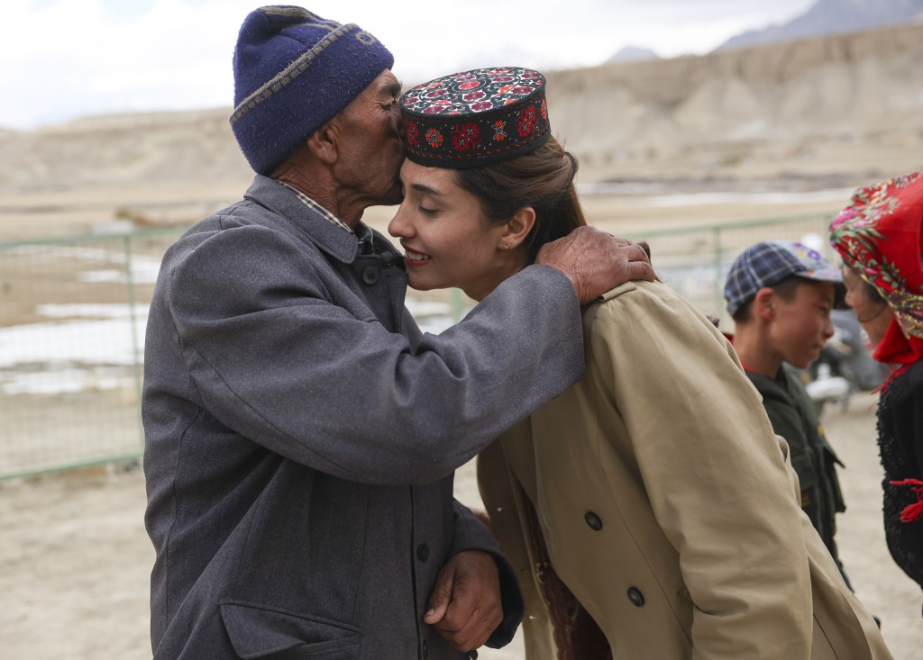 在新疆塔什库尔干塔吉克自治县瓦恰乡夏布孜喀拉村，爷爷（左）见到许久未碰面的艾尔开牙·多力开，按传统礼节亲吻孙女的额头。 新华社