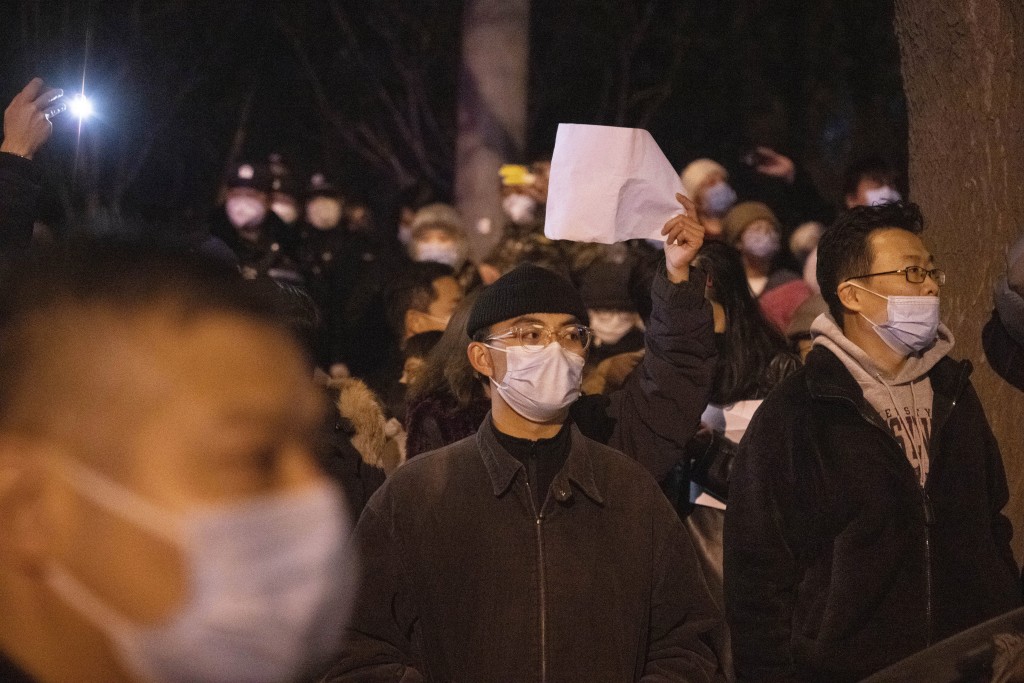北京市民昨深夜聚集在亮馬河，手持白紙表達抗議。AP