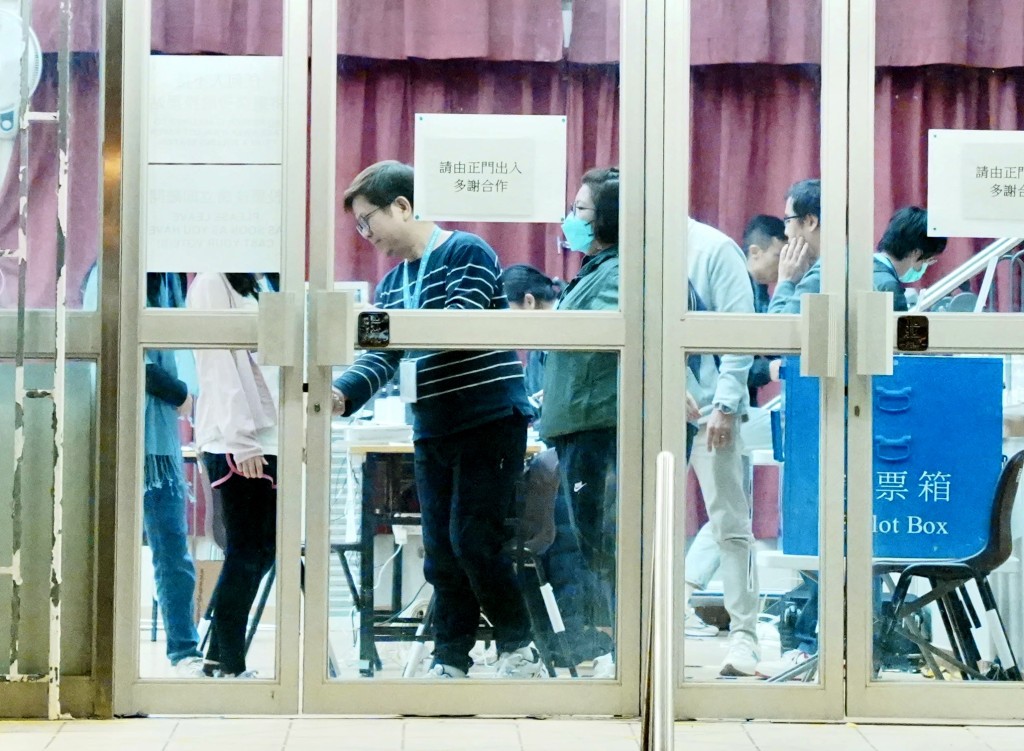 晚上11時30分投票結束,票站職員關上大門。 晚上11時30分投票結束,票站職員關上大門。