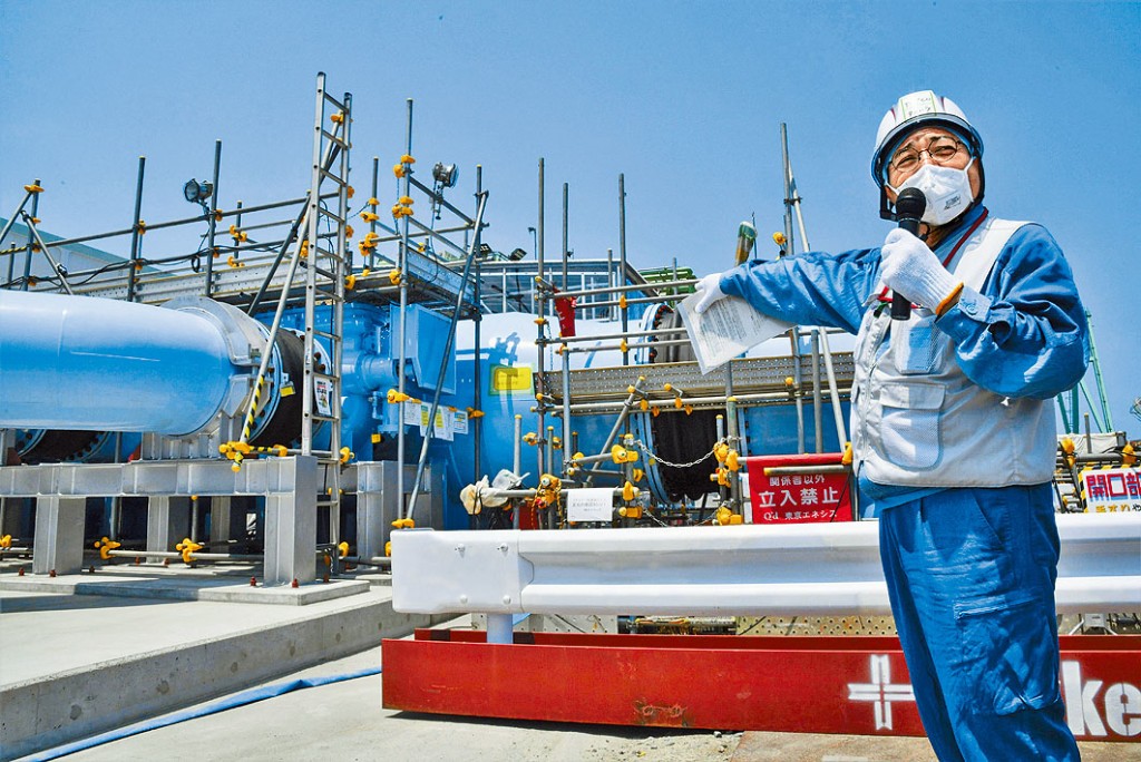 東京電力公司職員向媒體講解排放核廢水的設施。