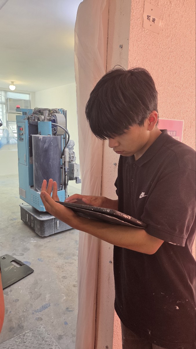 蔚建科技油漆機械人操作員,示範在比賽場地的門外操控噴油,避免吸入粉塵。 蔚建科技油漆機械人操作員,示範在比賽場地的門外操控噴油,避免吸入粉塵。