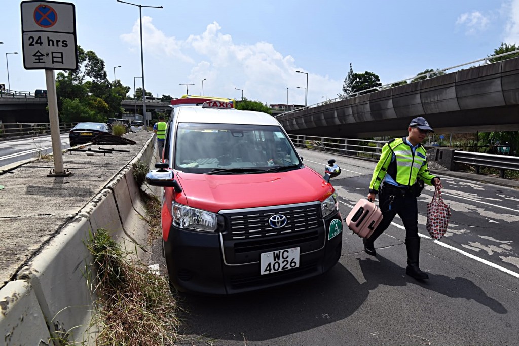 警員協助乘客搬行李往另一的士離去。梁國峰攝 警員協助乘客搬行李往另一的士離去。梁國峰攝
