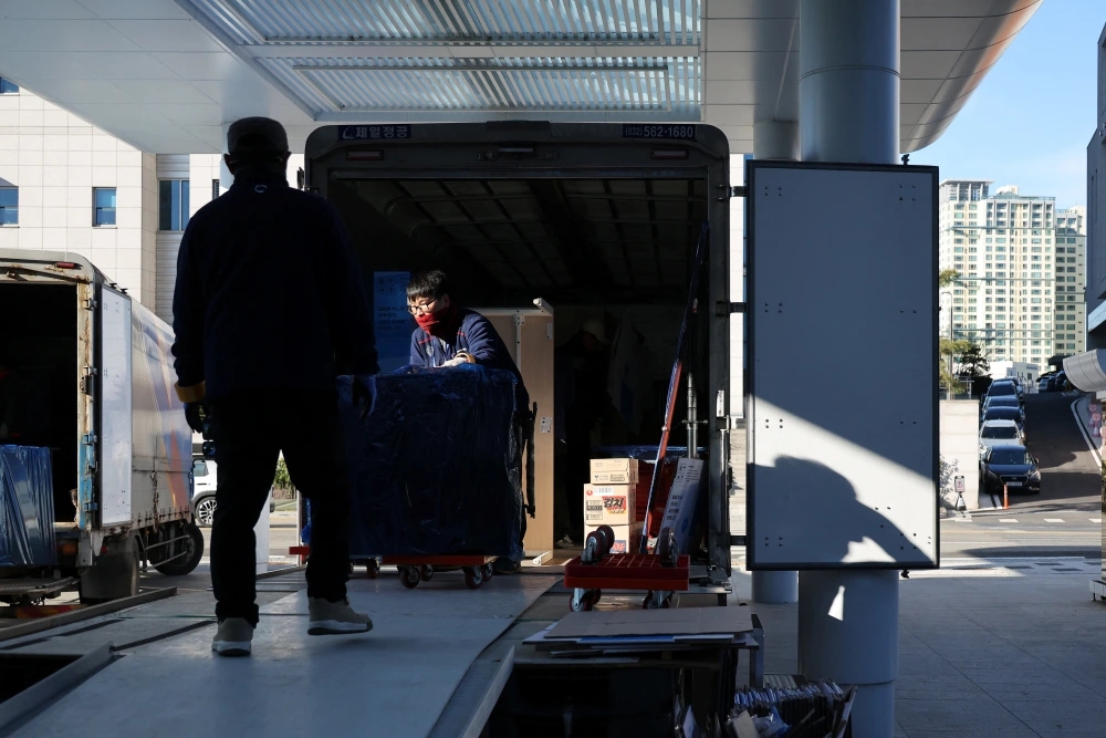 12月22日，在韓國首爾，工作人員在龍山總統府搬運辦公用品。新華社/路透社社