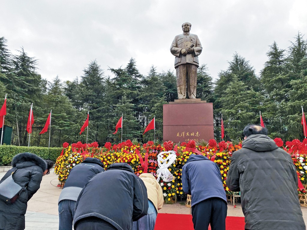 遊客向毛澤東銅像鞠躬。