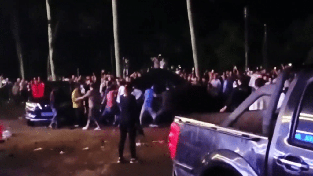 網片顯示,現場一群人破壞及推翻一輛汽車。 網片顯示,現場一群人破壞及推翻一輛汽車。